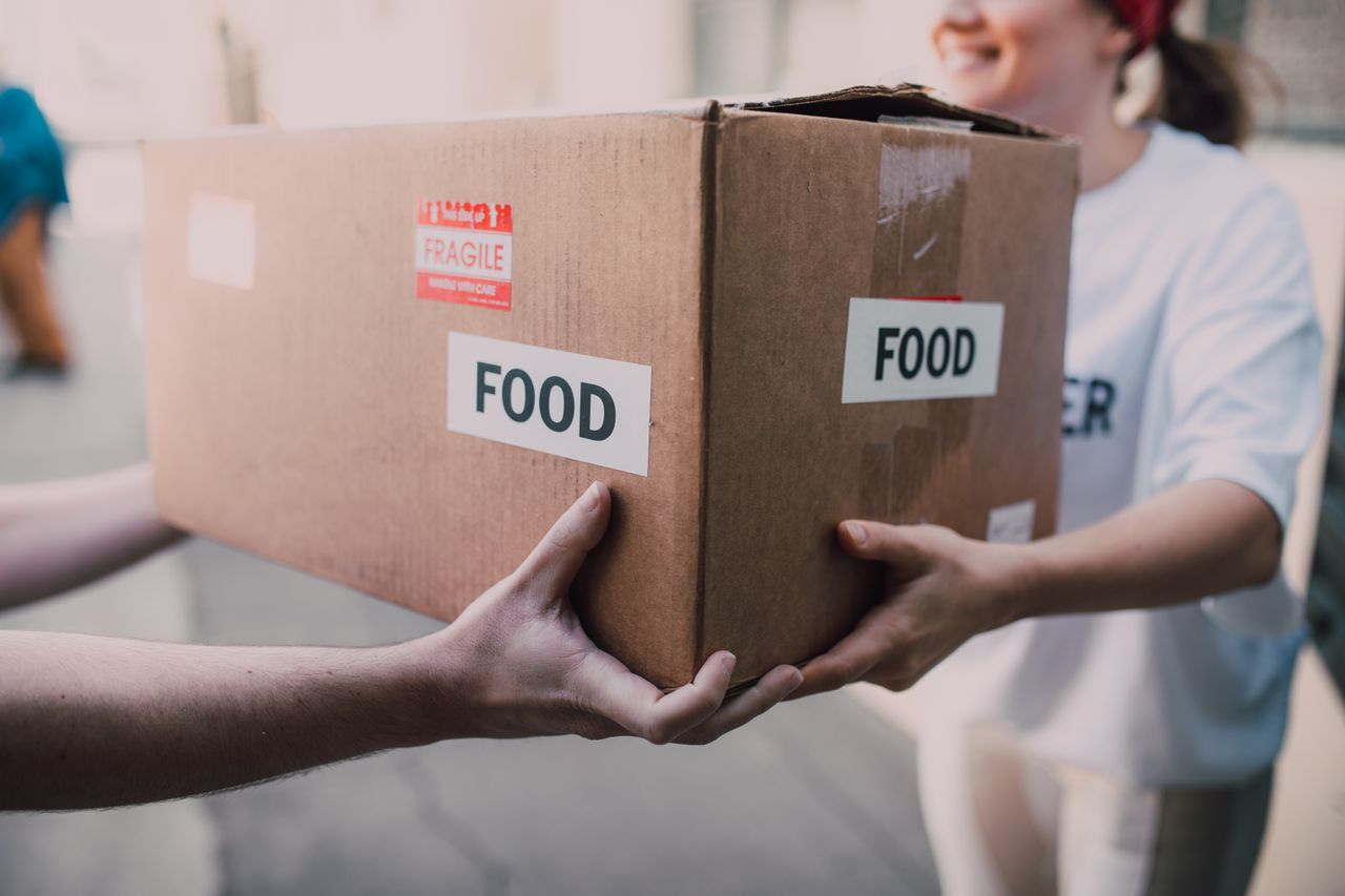 Crafting Captivating Headlines: Your awesome post title goes here Hands exchanging a box labeled 'Food', symbolizing charity and support.